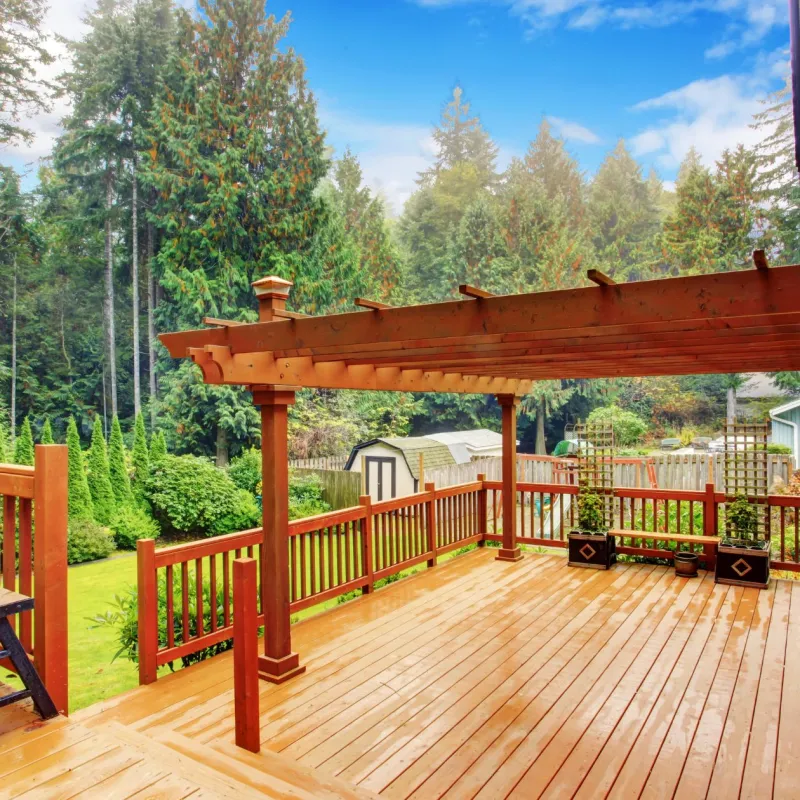 a deck with a gazebo and trees in the background