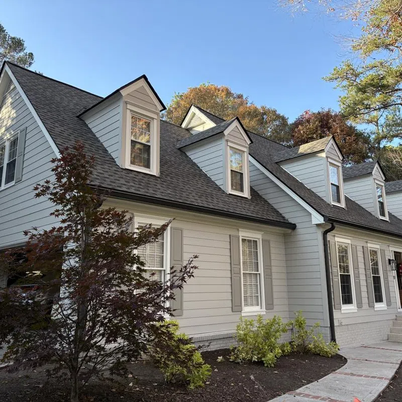 A beautiful two-story home displaying a brand-new architectural shingle roof with steep gables and dormers after a full exterior replacement project by Nelson Exteriors.
