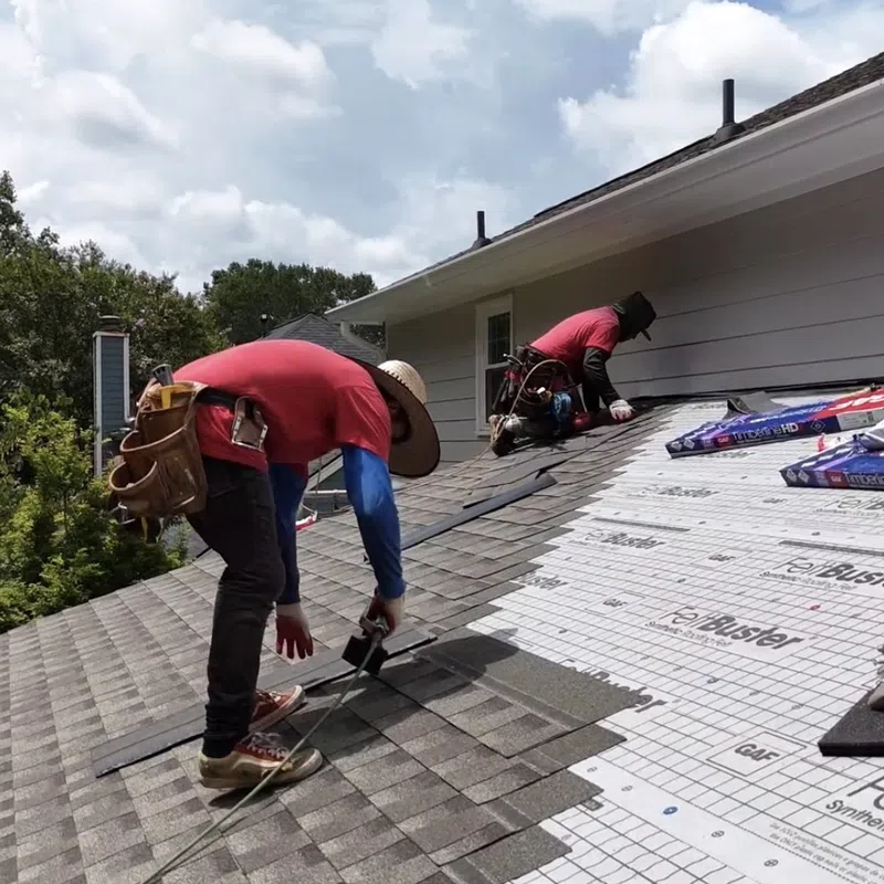 Roofers laying architectural asphalt shingles over synthetic underlayment to cover each hundred-square-foot section, demonstrating what is a roofing square during residential roof replacement in Marietta by Nelson Exteriors.