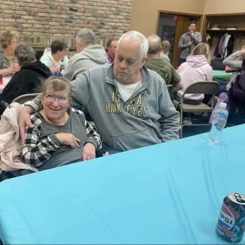 a man and a woman sitting at a table with a blue tablecloth