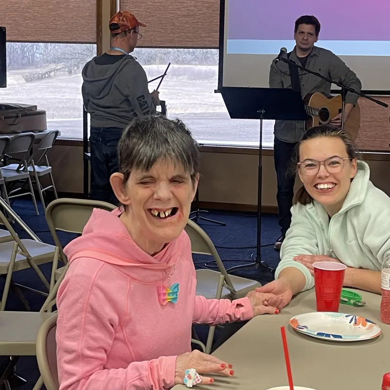 a group of people sitting at a table smiling for the camera