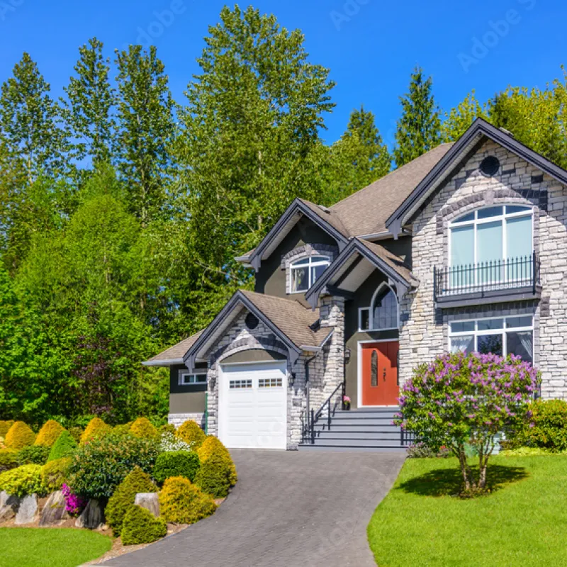 a house with a driveway and trees around it
