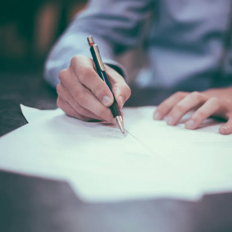 a person writing on a piece of paper