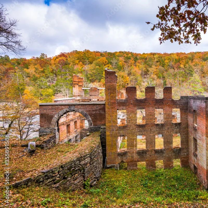 a stone building with a hill in the background