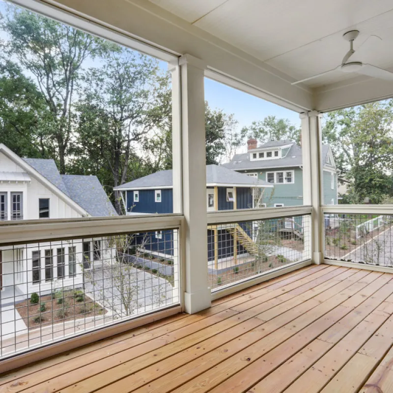 a deck with a view of a house and trees