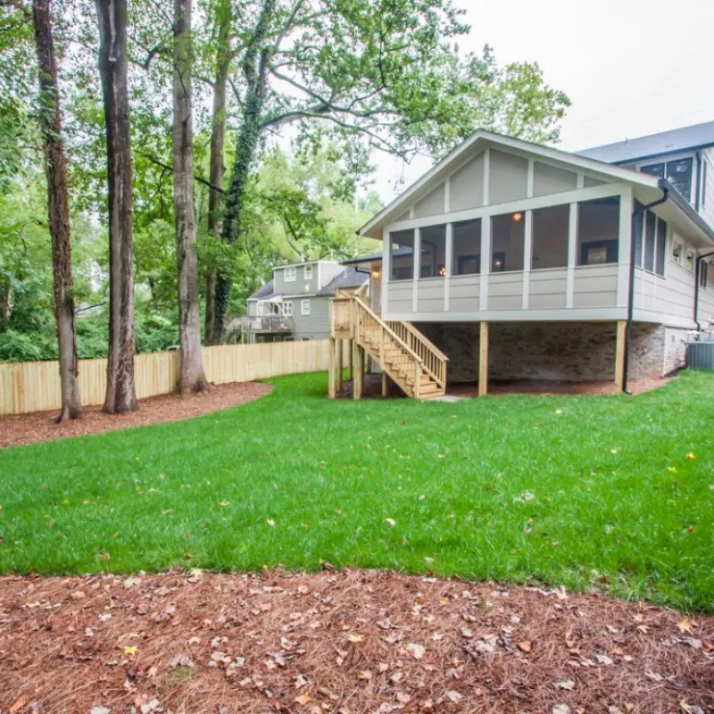 a house with a fence and trees around it
