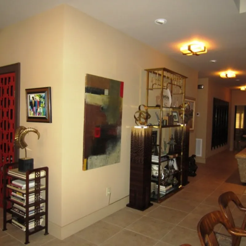 a room with a shelf and art on the wall