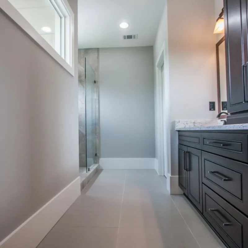 a room with a shower and cabinets