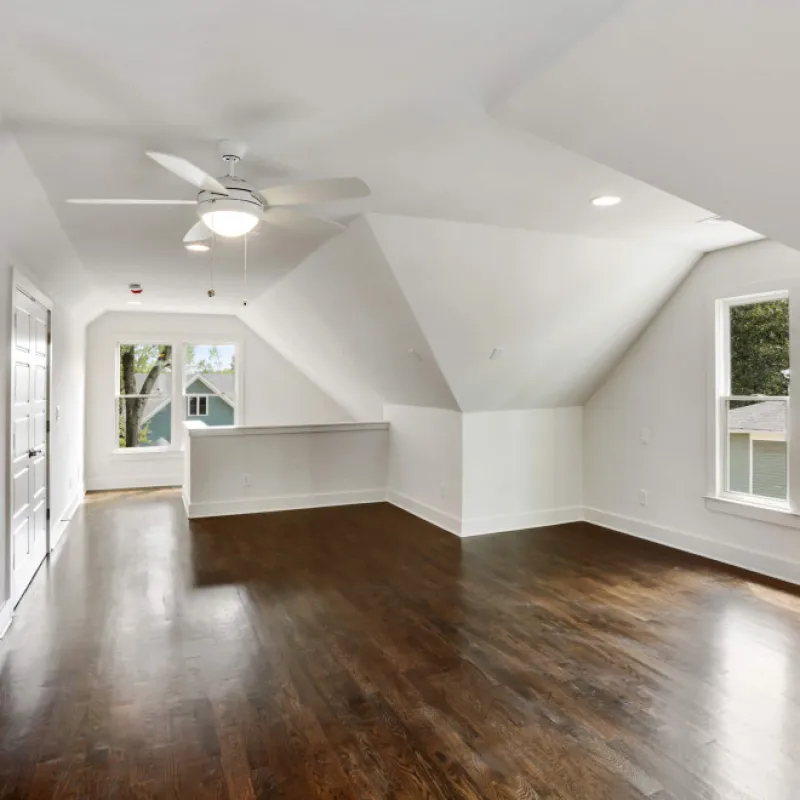 a room with a wood floor and white walls