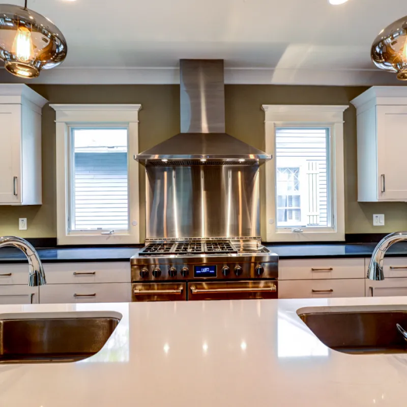 a kitchen with a large stainless steel stove and a large metal pot on top