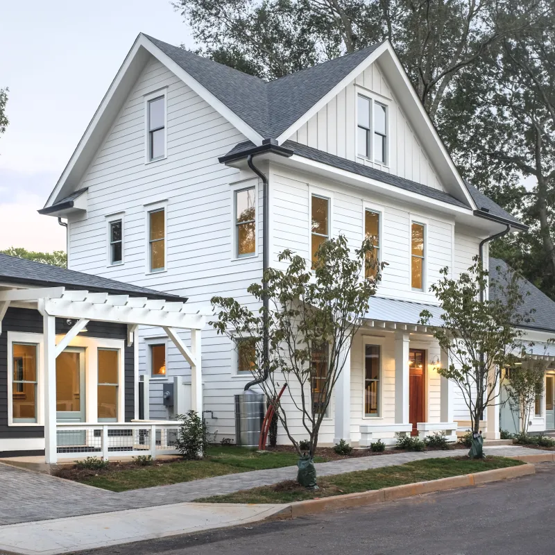 a white house with trees and a driveway