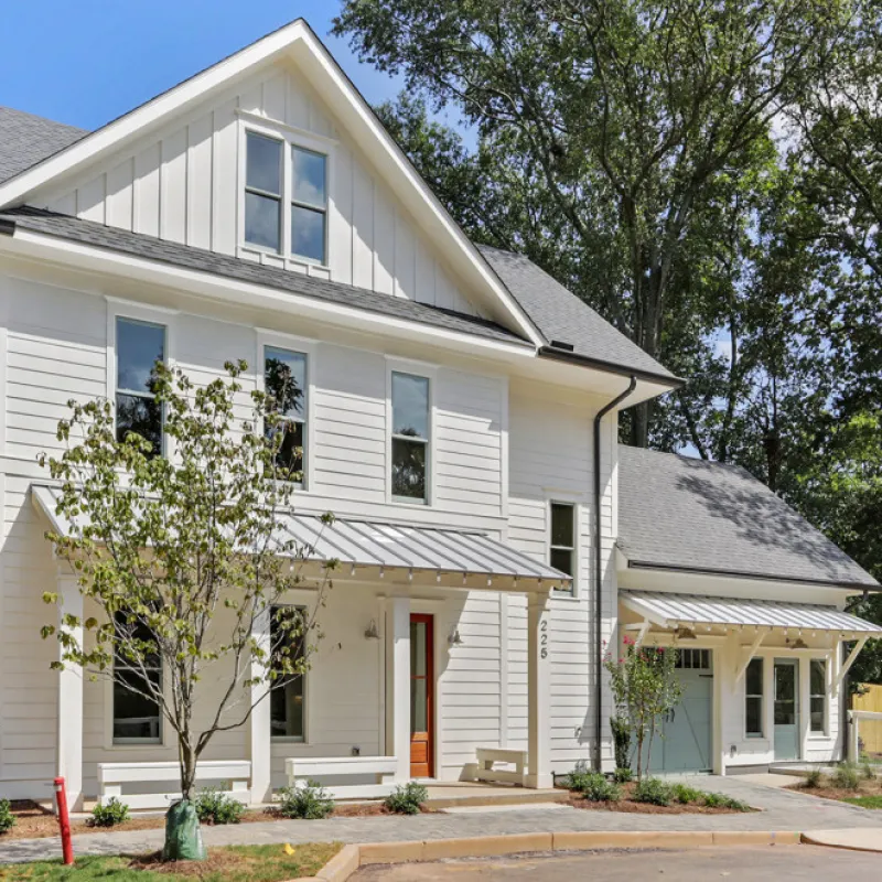 a white house with trees and a driveway