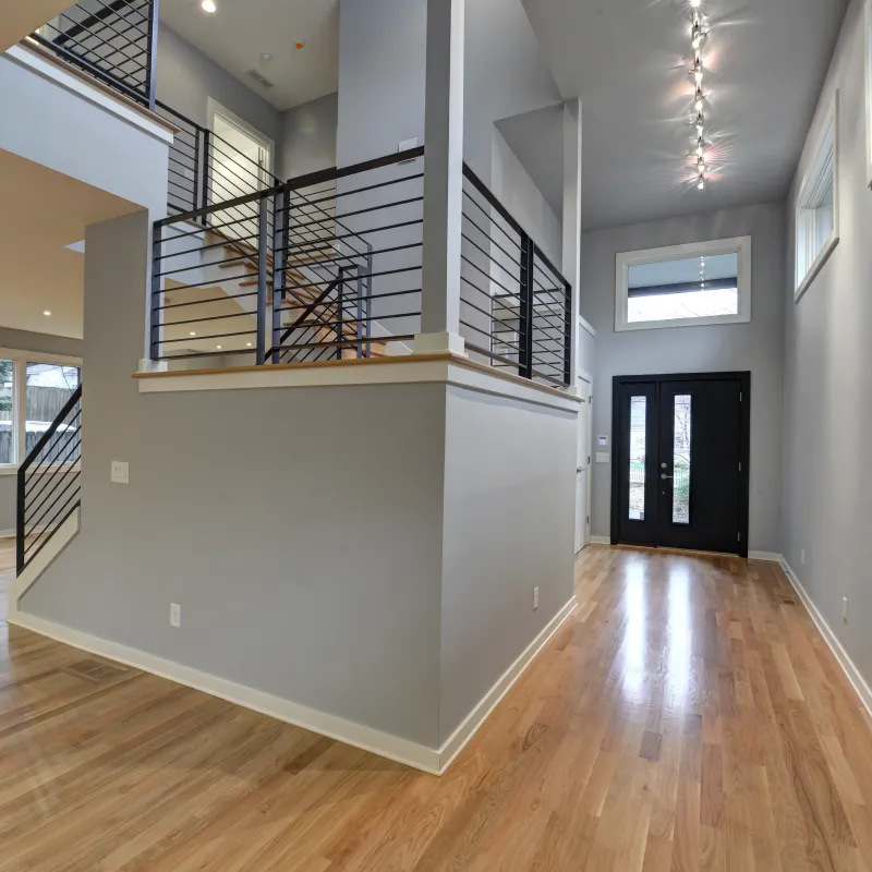a room with a wood floor and a wood floor with a staircase