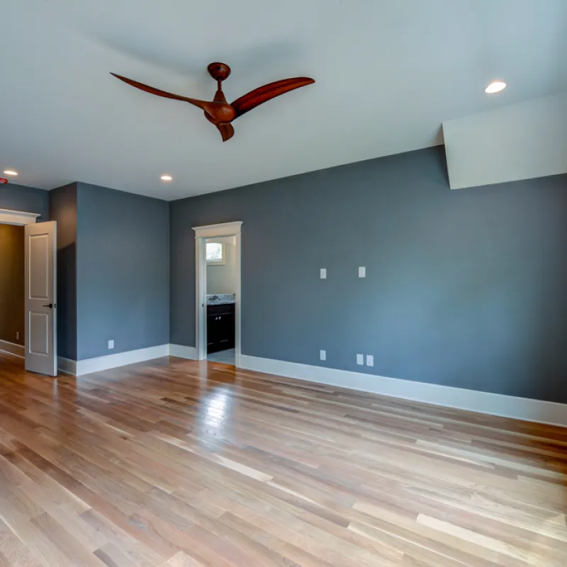 a room with a wood floor and a wood floor with a red object on the wall