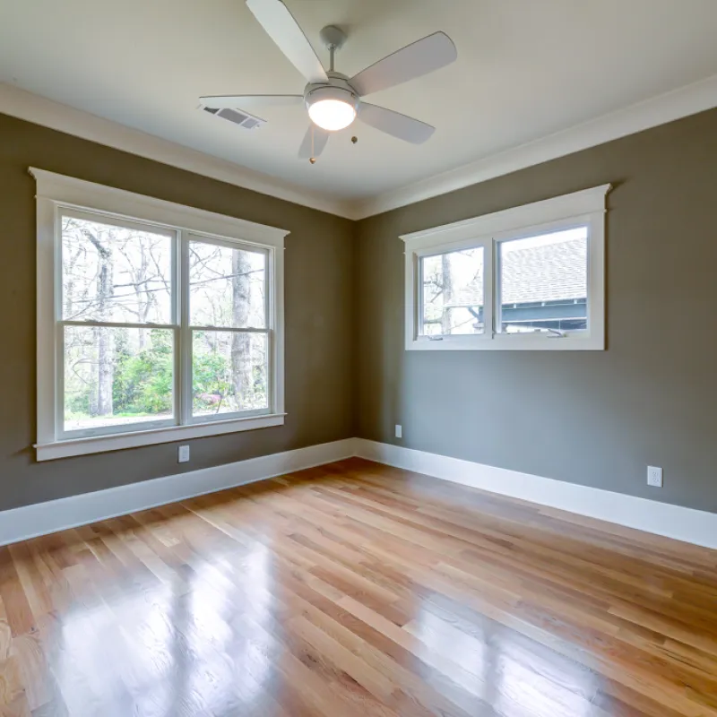 a room with a wood floor and a ceiling fan