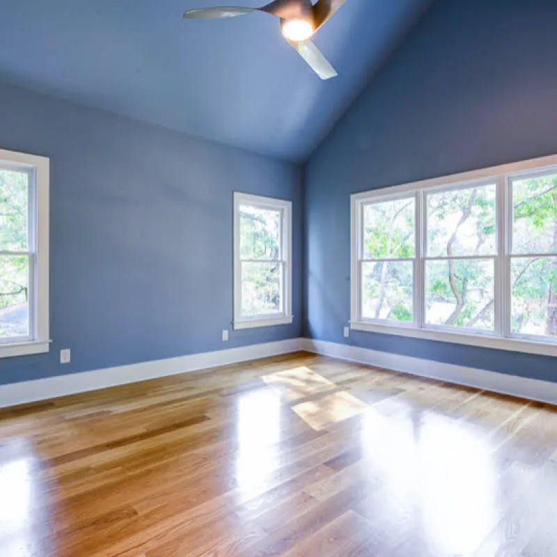 a room with a wood floor and windows