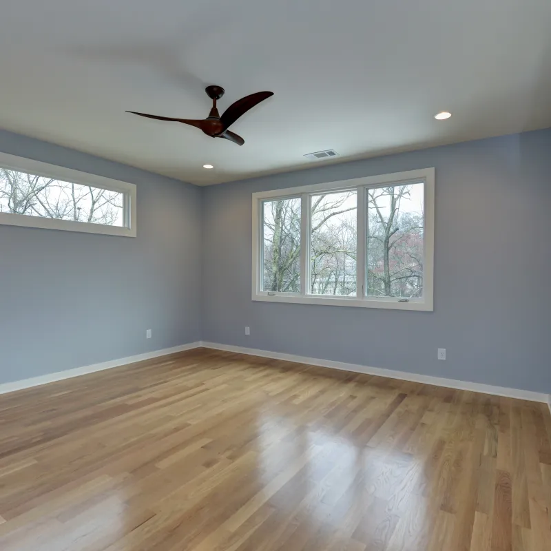 a room with a wood floor and a ceiling fan