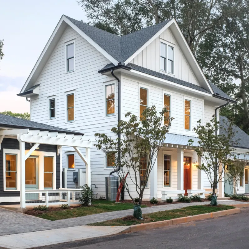 a white house with trees and a driveway
