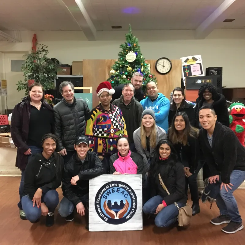 a group of people posing for a photo in front of a christmas tree