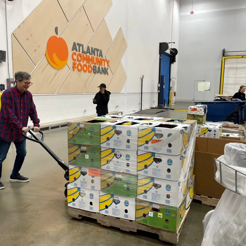 a person with a broom in a room full of boxes