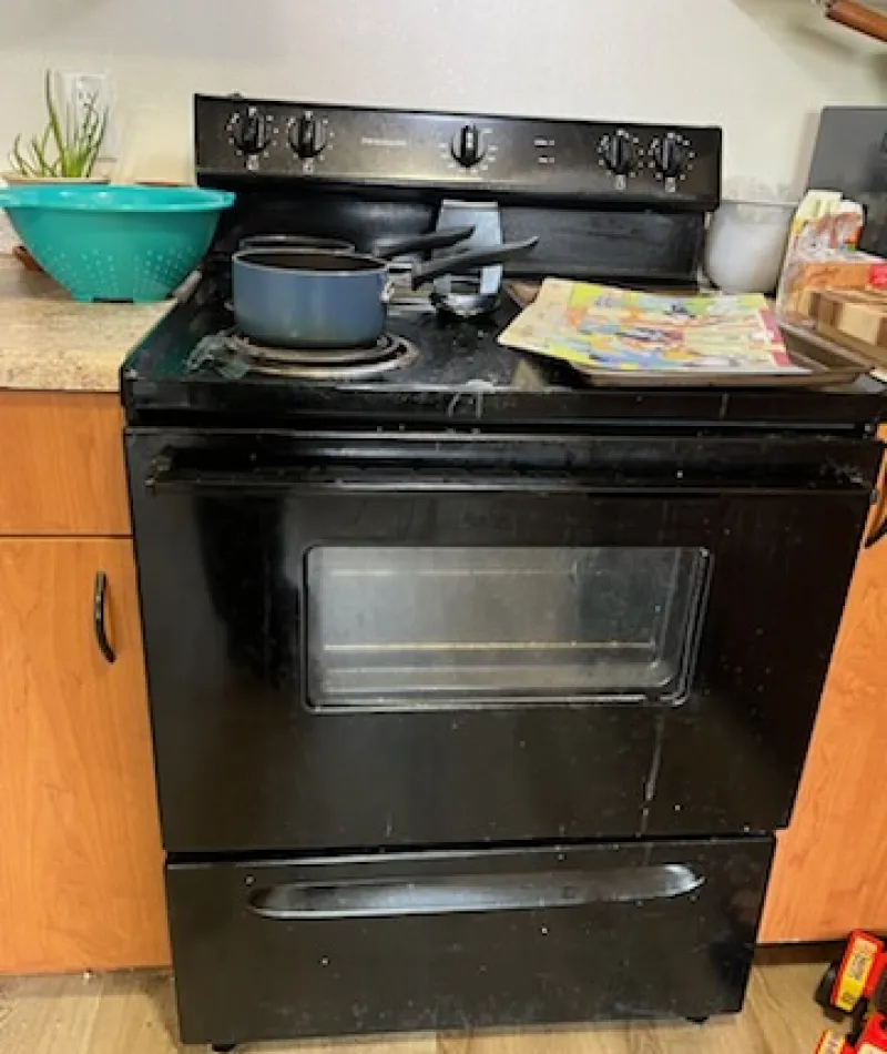 Black stove with a pan on top and various items in a kitchen setting
