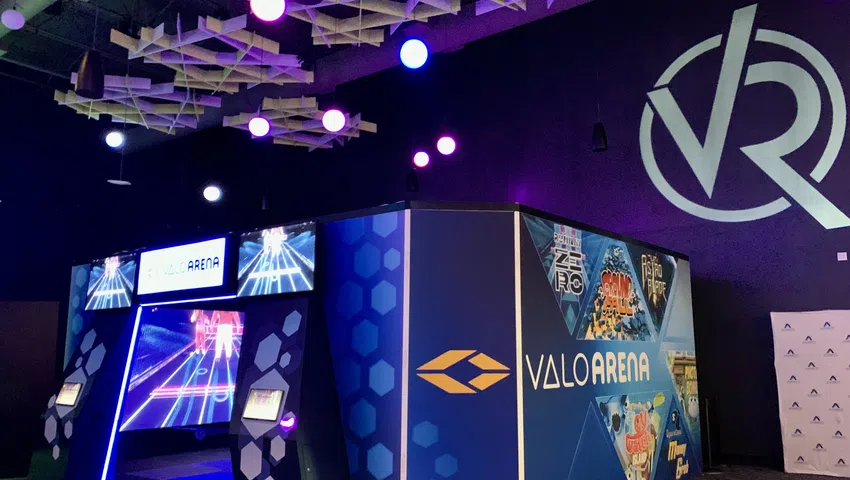 Colorful ValoArena VR gaming setup with vibrant lights and modern design in a spacious arcade.