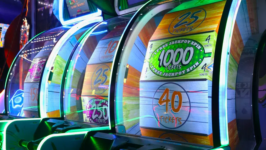Colorful arcade ticket redemption games with spinning wheels and bright neon lights in a gaming venue.