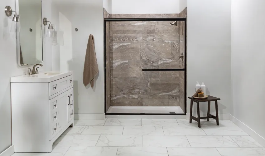 Modern bathroom with large walk-in stone tile shower, white vanity, and minimalist decor on marble floor.