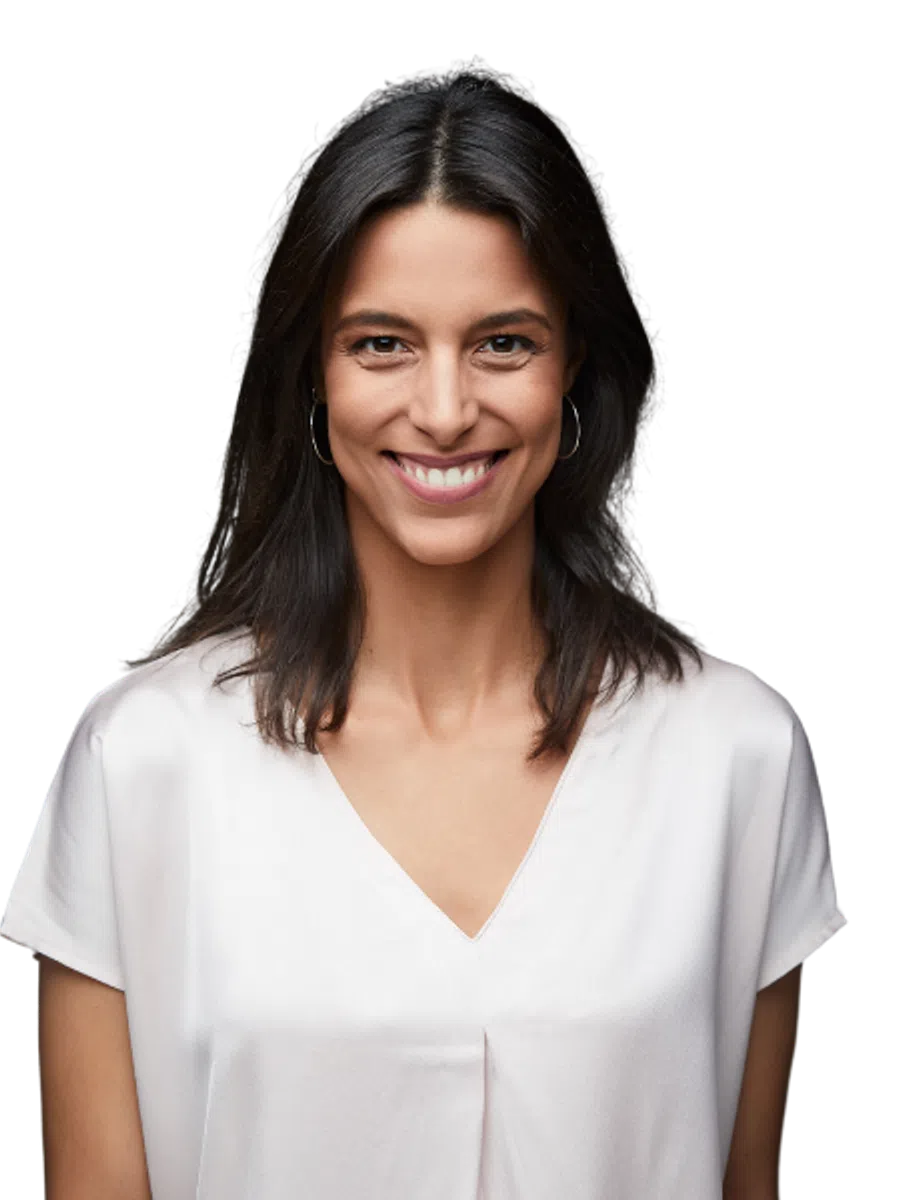 Smiling woman with dark hair wearing a white blouse and hoop earrings looking confidently at the camera