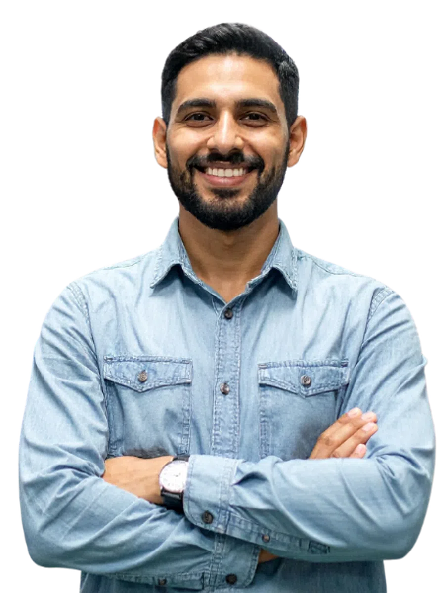 Smiling man with beard and mustache wearing a light blue denim shirt with arms crossed