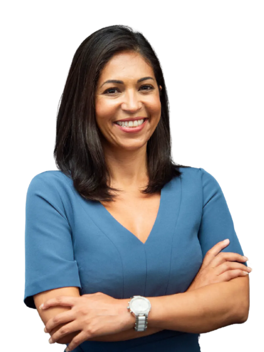Confident woman with crossed arms wearing a blue dress and silver wristwatch smiling at the camera.