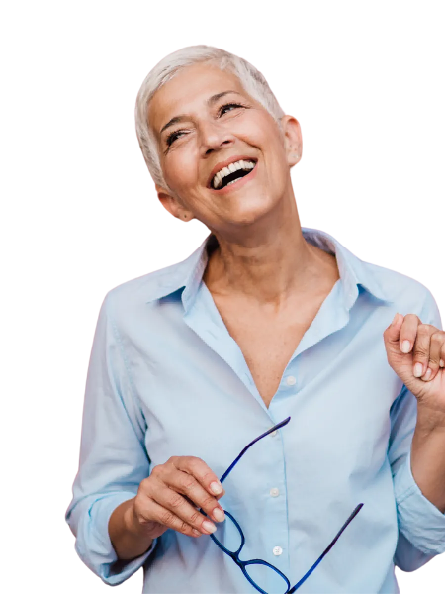 Smiling senior woman with short white hair holding glasses wearing a light blue shirt isolated on white