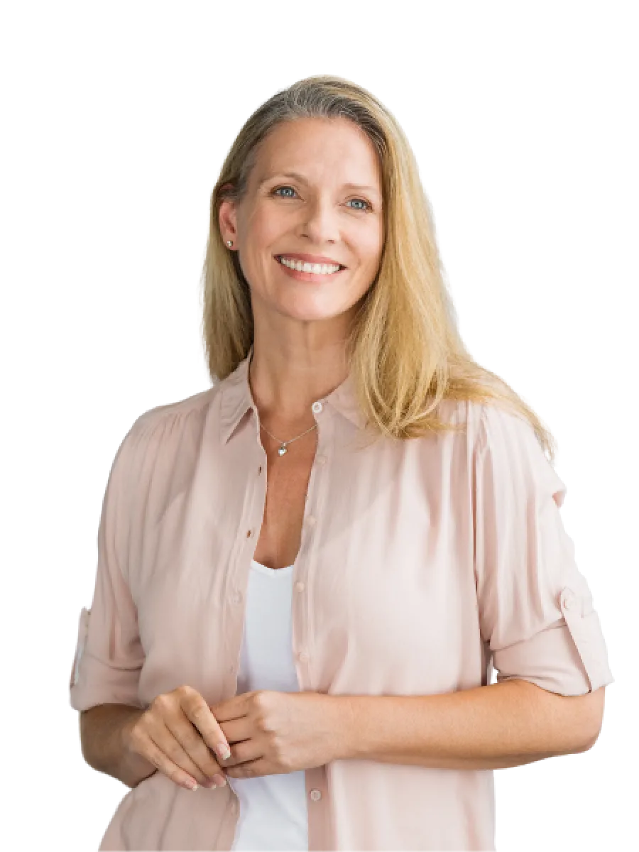 Smiling middle-aged woman with blonde hair wearing a light pink shirt and white top, posing with hands clasped.