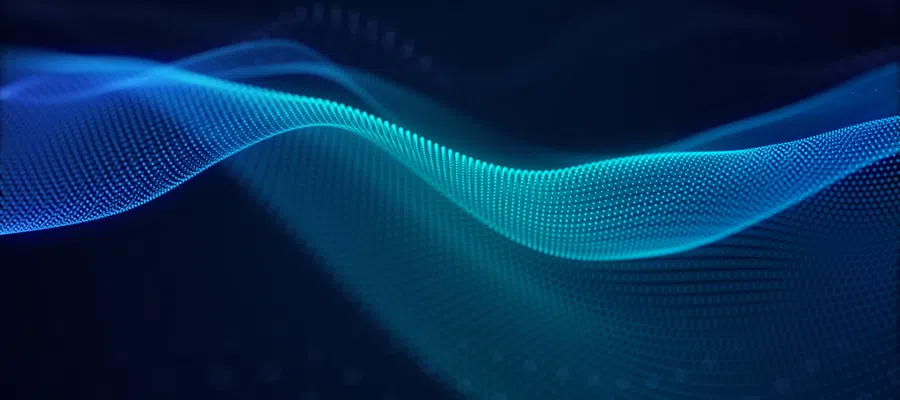 Flowing blue digital wave made of particles on a dark background representing technology and data.
