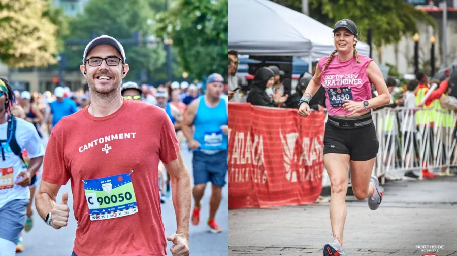 Smiling male and female runners wearing race bibs participate in a city marathon with spectators in the background.