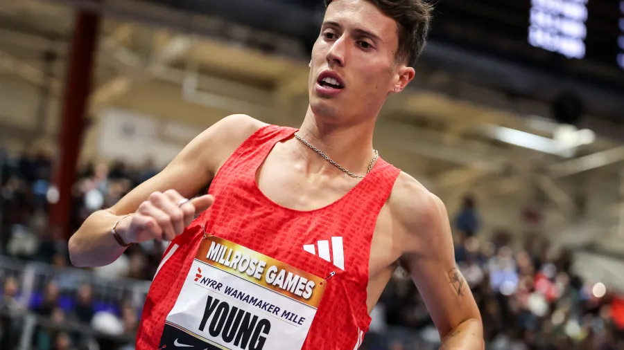 Male runner in red Adidas singlet competes in the Millrose Games Wanamaker Mile indoor track race