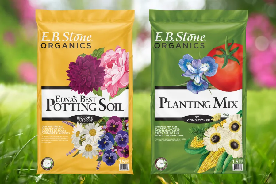 E.B. Stone Organics Edna's Best Potting Soil and Planting Mix bags with floral and vegetable illustrations on grass background