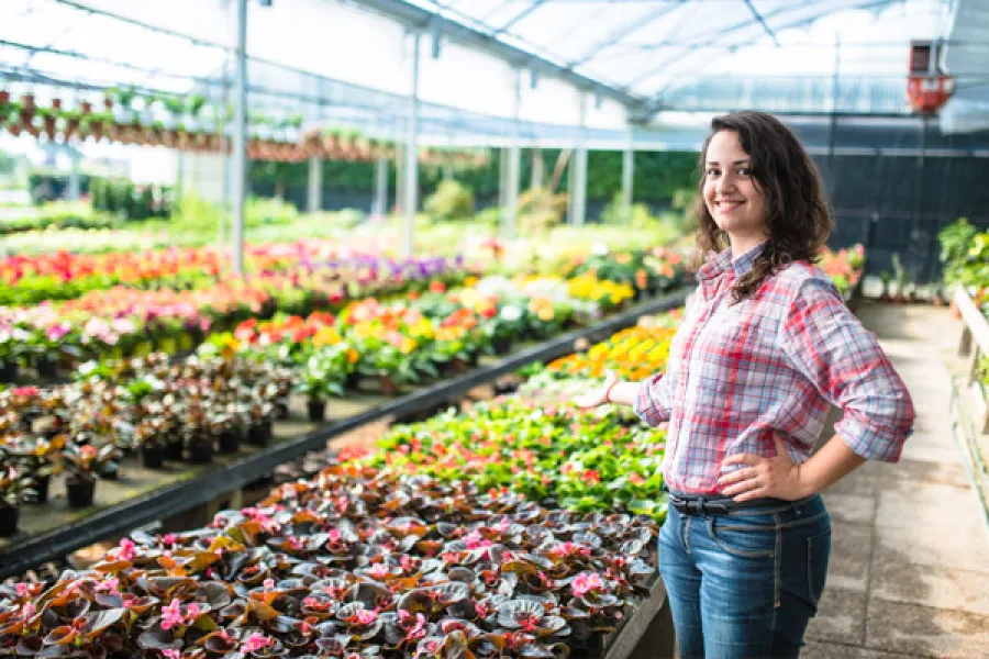 a woman standing in a greenhouse