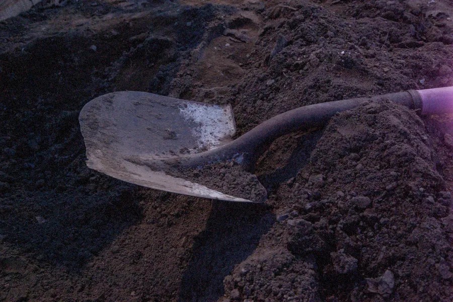 a shovel laying on top of a hole in the ground