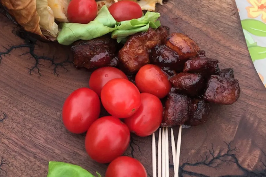 garden tomatoes and pork on a cutting board
