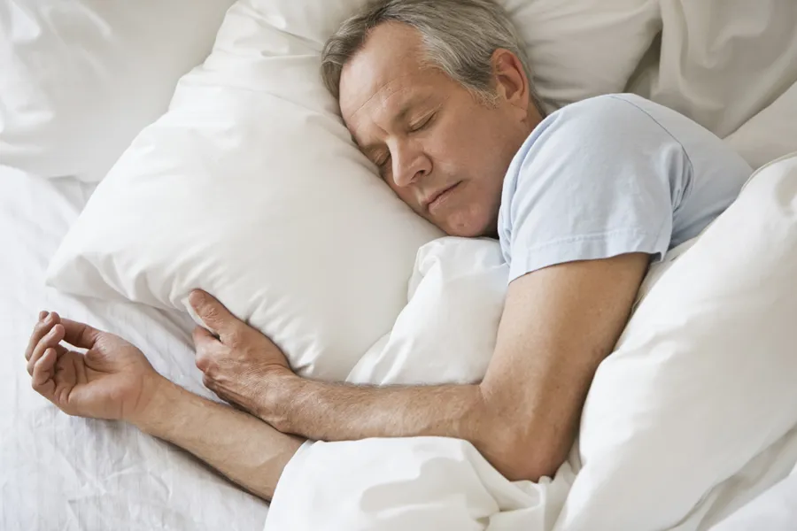 a man lying on a bed sleeping