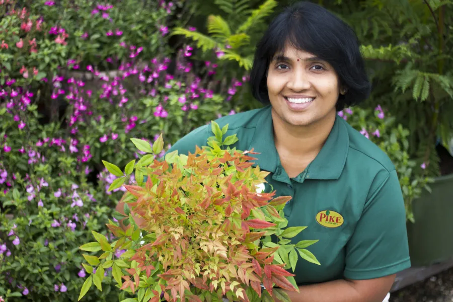 a person standing in a garden smiling