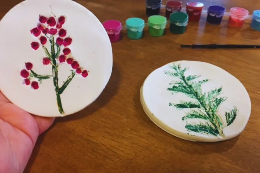a hand holding a clay fossil