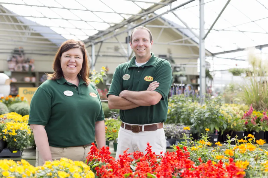 a man and a woman standing in front of a flower