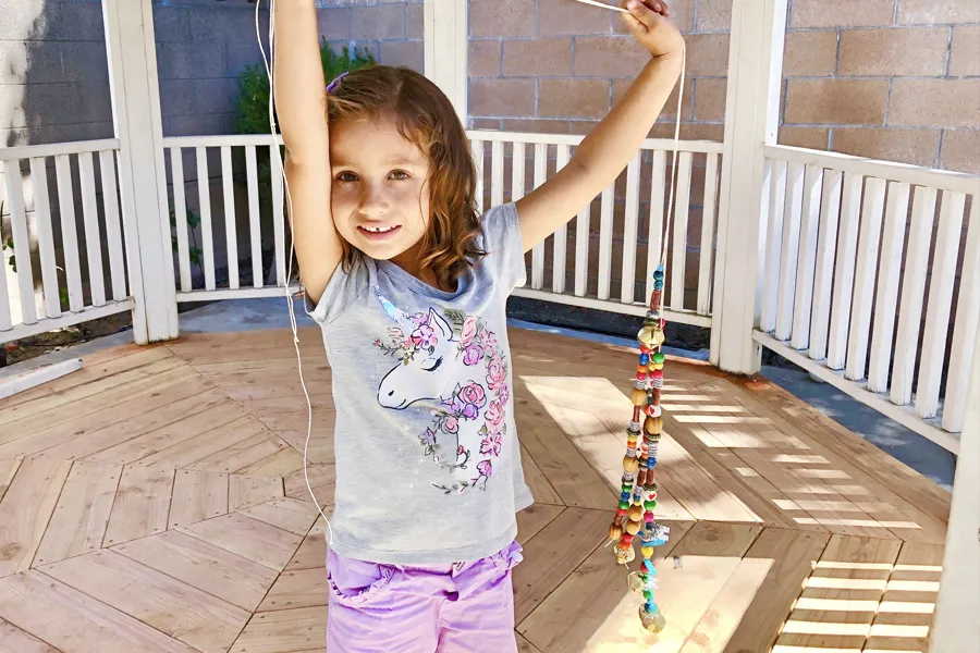 girl holding twine with beads
