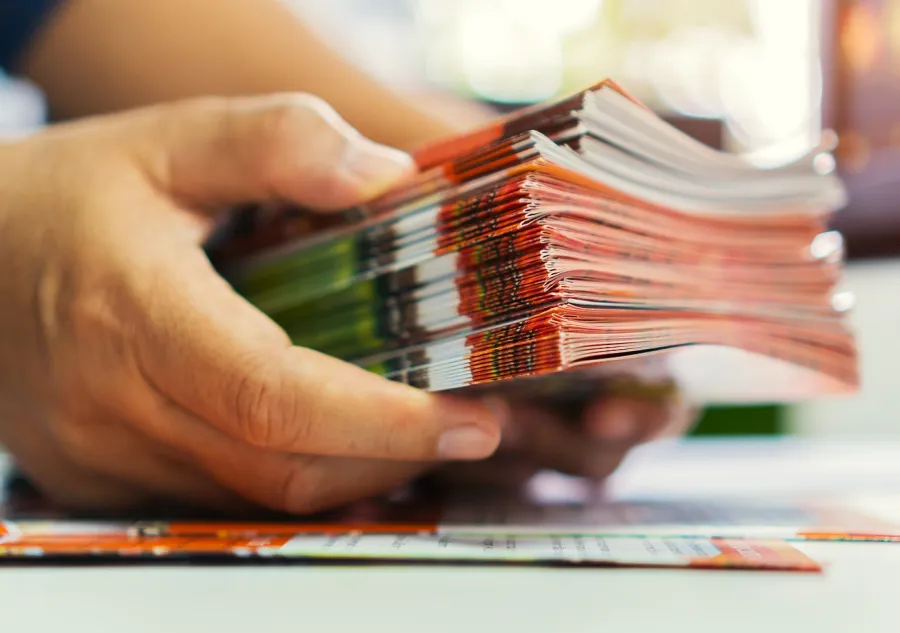 Two hands holding a stack of Folded Brochures