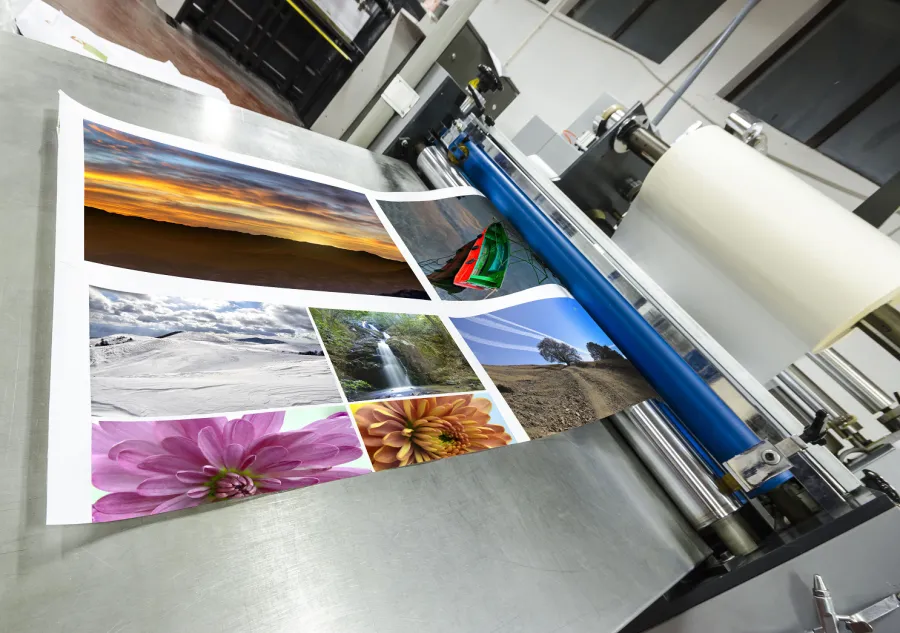 A commercial laminator applying plastic film over full color print project