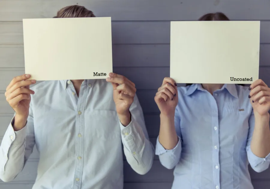 A man and a woman holding up one sheet of paper each