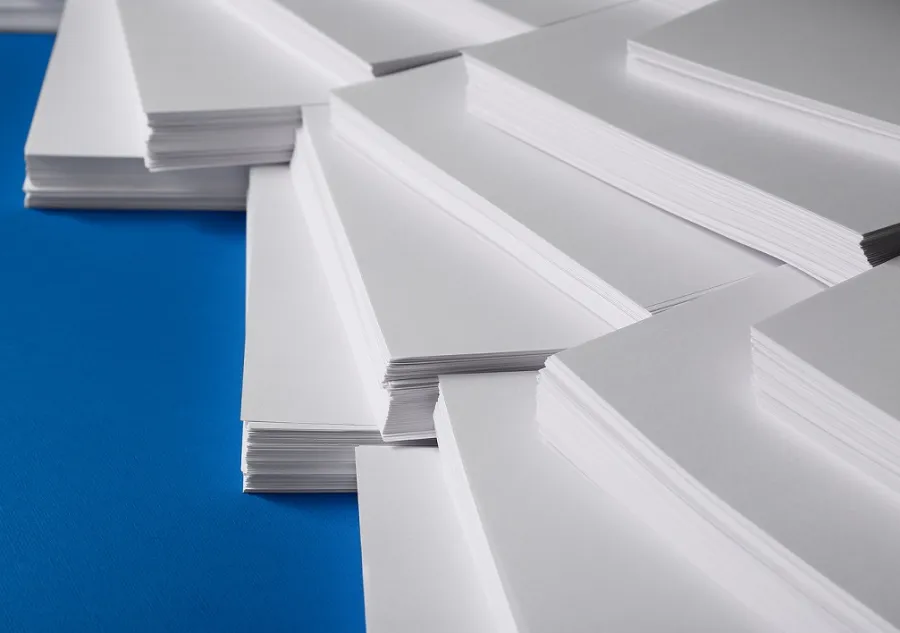 Stacks of large paper sheets lying on a blue surface