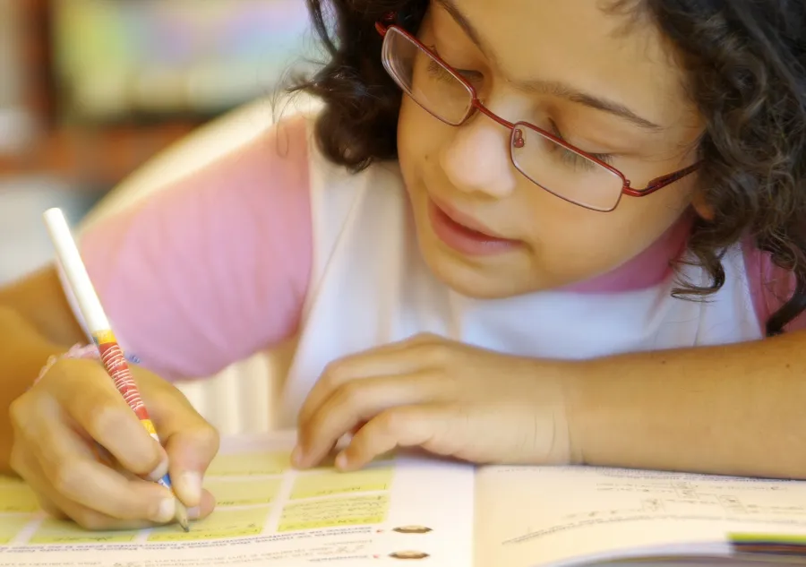 Young female student writes in a workbook